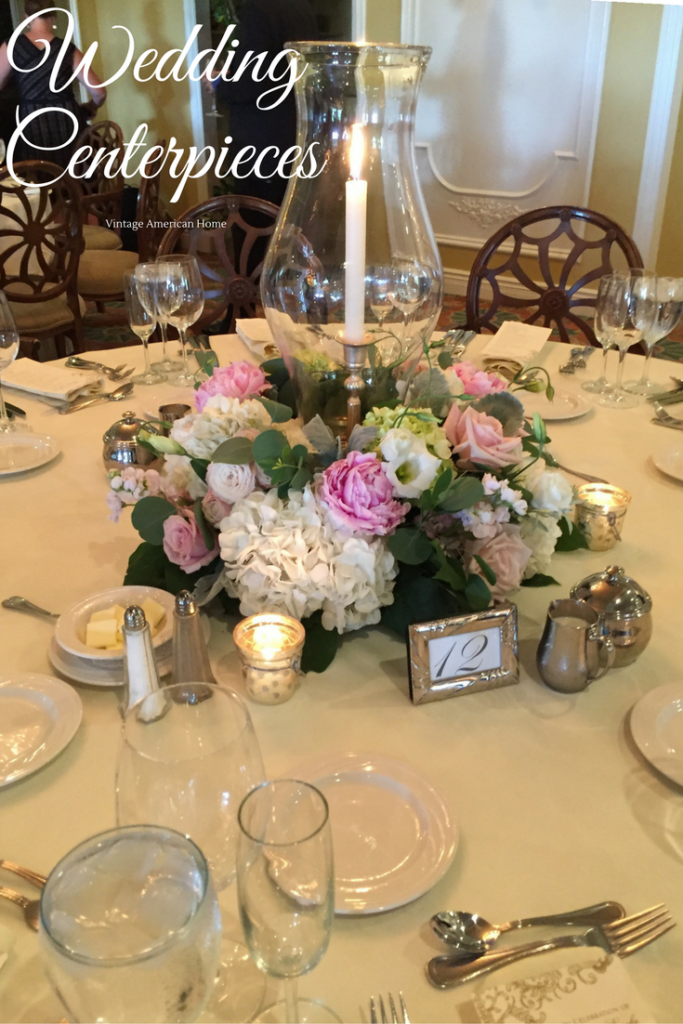 WEdding Centerpieces with peony, rose and hydrangea wreath surrounding Williamsburg hurricaine and single taper candle in silver candlestick from Vintage American Home