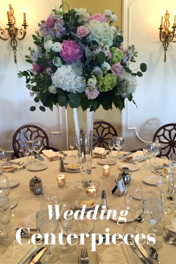 Tall wedding centerpiece in glass trumpet vase with peopnies , hydrangeas and roses with pink and white and blush theme.